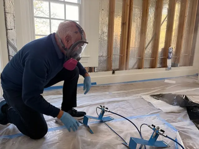 A restoration technician setting drying equipment in an Miami home stripped to the studs
